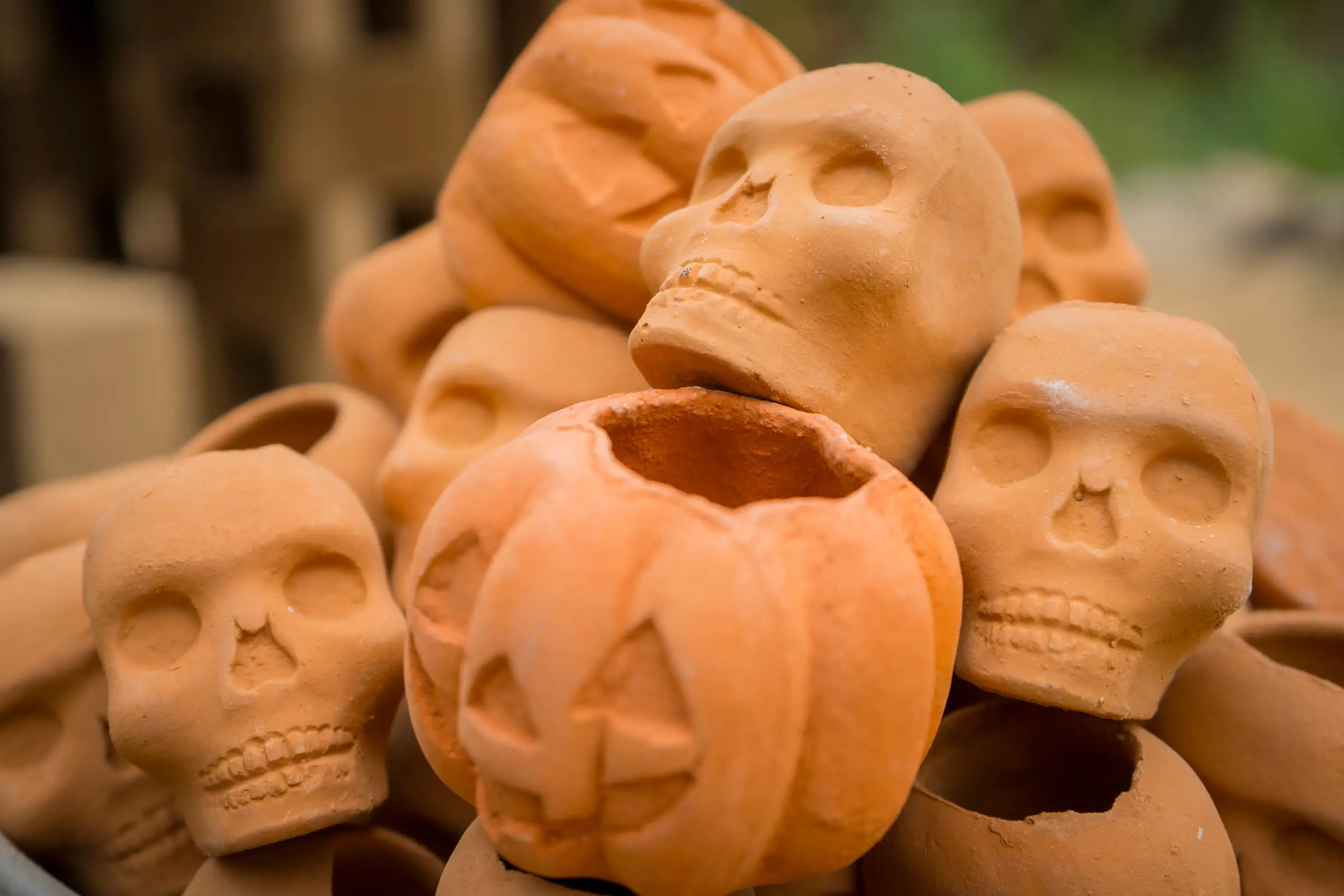 Calaveras y calabazas de barro cocido apiladas