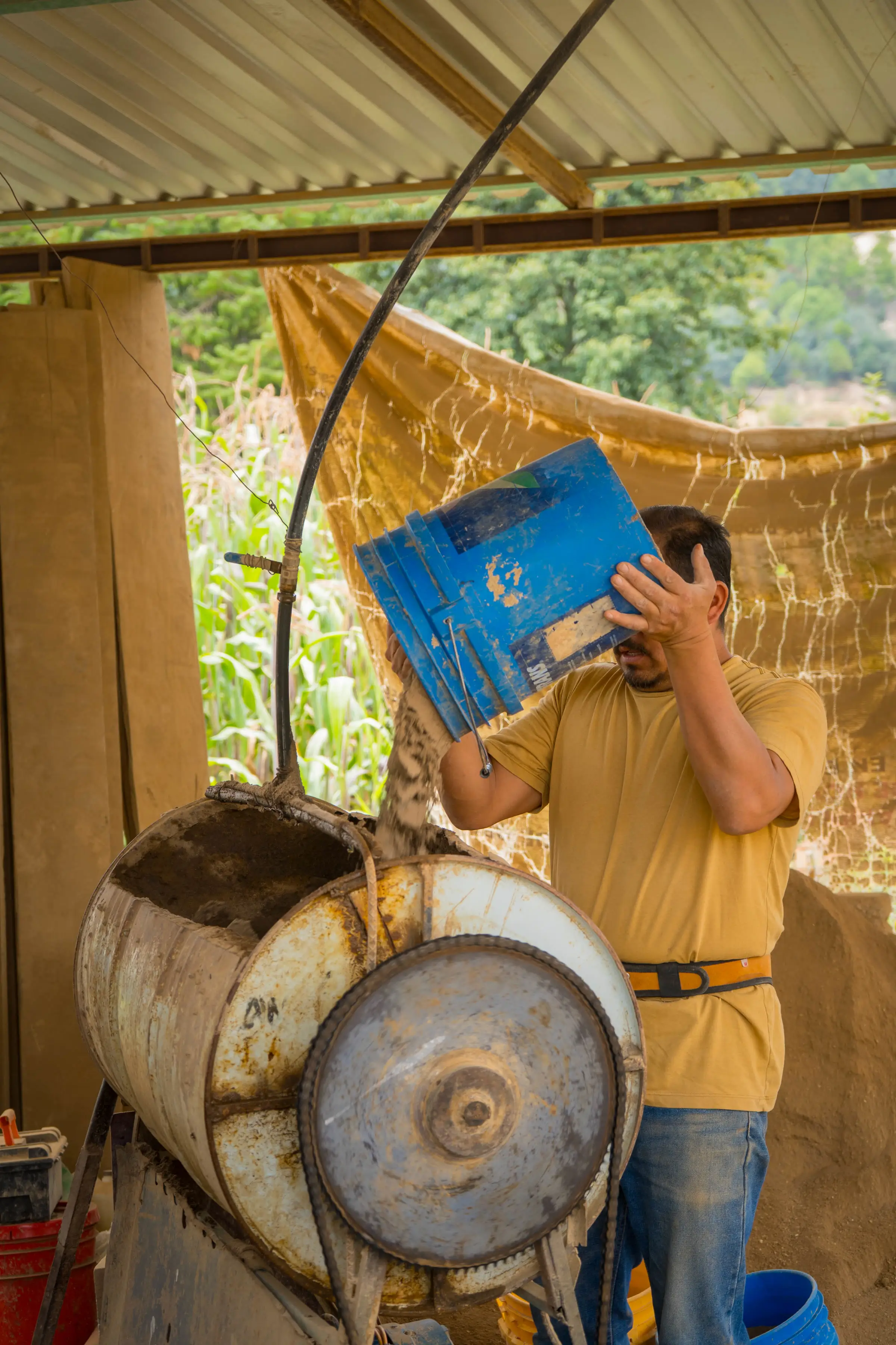 Trabajador vaciando material en la mezcladora