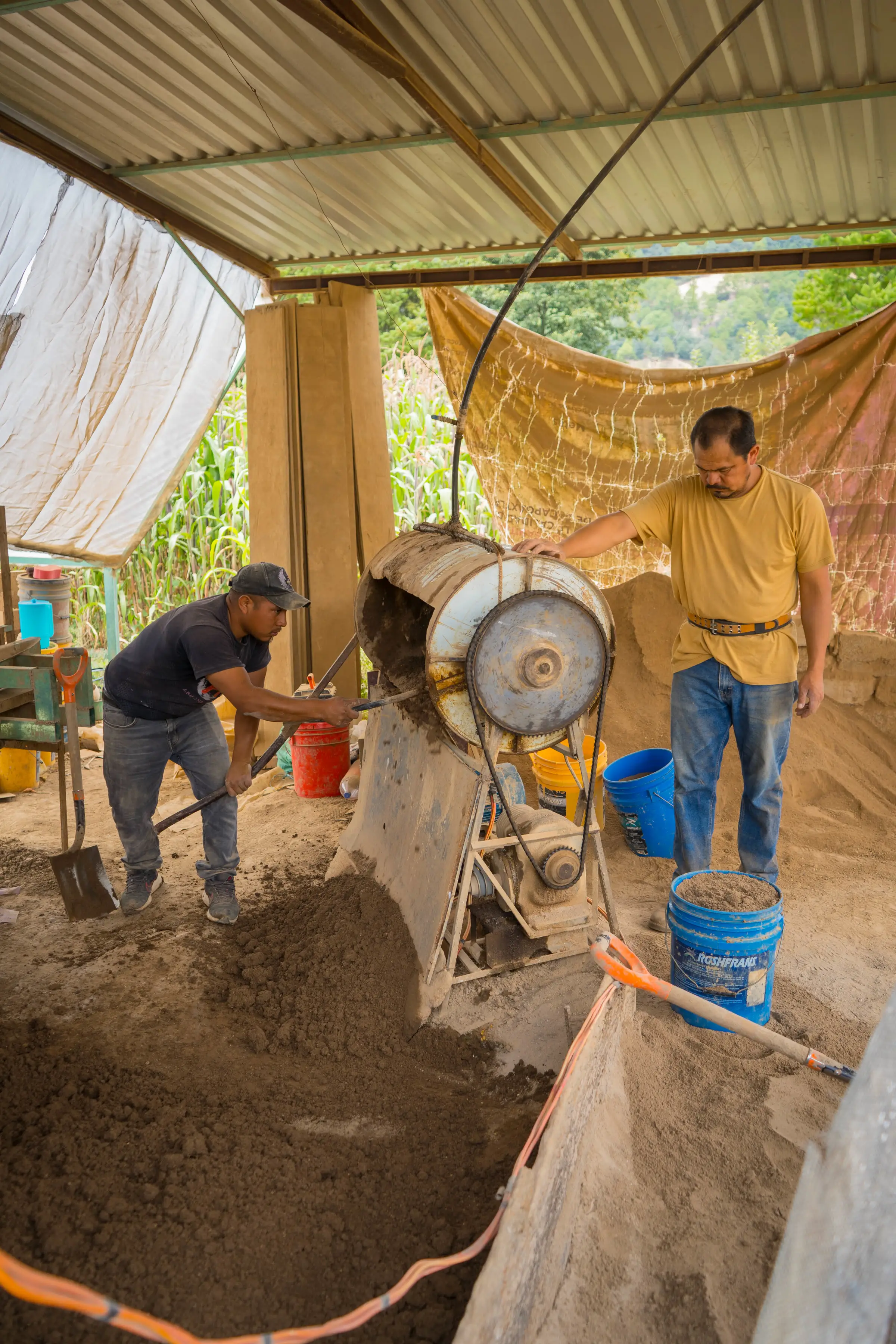 Trabajador extrayendo barro del banco junto al taller